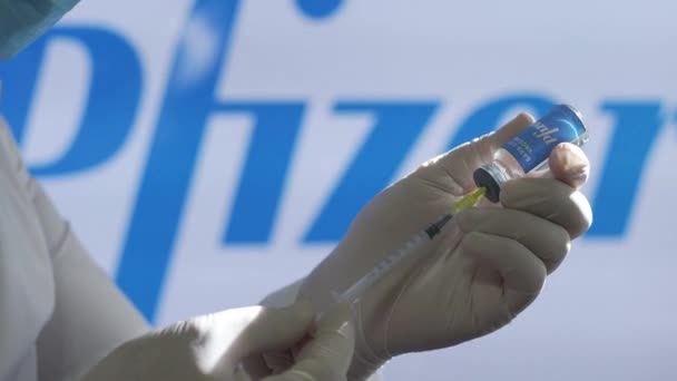 O médico assistente prepara a injeção da vacina Pfizer durante uma vacinação em massa no centro de saúde. Vacina contra o Coronavirus — Vídeo de Stock
