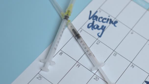 Dvě injekční stříkačky a měsíční kalendář — Stock video