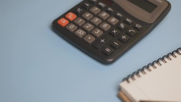 Calculator and notepad on desk — Stock Video