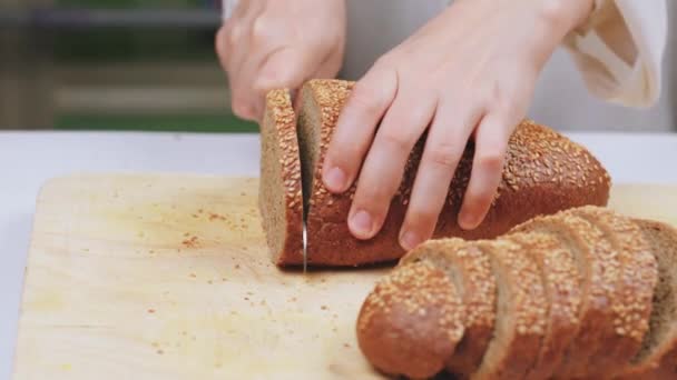Человек режет хлеб — стоковое видео