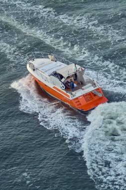 Venice. Italy - October 08, 2025: An aerial view of a high-performance pleasure craft creating a large wake, illustrating speed, power, and adventure.