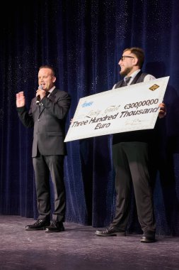 Venice. Italy - October 08, 2025: A host with a microphone announces the winner of a large lottery or casino grand prize on stage at a celebratory event.
