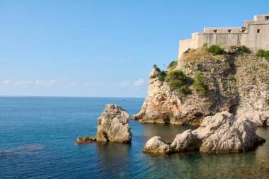 Dubrovnik 'teki güneşli yaz sahnesi. Kadim taş tahkimatları Dalmaçya kıyılarına tepeden bakıyor. Seyahat, turizm ve UNESCO mirası kavramı.