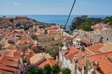 Hırvatistan 'ın eski Dubrovniks kentinin hava manzarası. Terracotta çatıları, saat kulesi ve Lovrijenac Kalesi güneşli bir günde arka planda mavi denizle birlikte görülüyor..