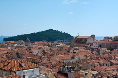 Hırvatistan 'ın başkenti Dubrovniks' teki terracotta çatılarının ikonik yüksek açılı manzarası. Lokrum Adası mavi Adriyatik Denizi 'nde yer alır. Bir UNESCO Dünya Mirası sahası.