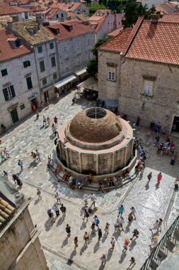 Dubrovnik. Hırvatistan - 14 Kasım 2025: Turistlerin yüksek açılı manzarası tarihi Onofrios Büyük Pınarı etrafında toplandı. Dubrovniks Eski Kasabası 'nda insanlar kireçtaşı kaldırımında yürüyor.