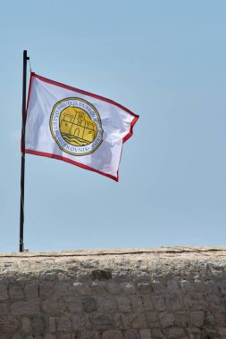 Dubrovnik. Hırvatistan - 14 Kasım 2025: Dubrovnik Antikacılık Dostları Derneği 'nin bayrağı (Drustvo prijatelja dubrovacke starine) tarihi kent duvarlarında mavi gökyüzüne karşı dalgalanır.