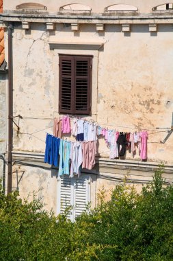 Basit ve sürdürülebilir bir yaşam konsepti. Eski bir Akdeniz evinde aile çamaşırları güneşte kurutulur, duvar dokusu ve otantik yaşam sergilenir..