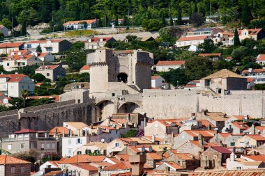 Minceta Kulesi ve Dubrovnik şehir duvarlarının yüksek açılı görüntüsü. Eski şehrin kırmızı çatıları ön planda, yamaç kenti arka planda..