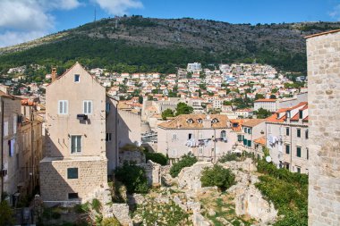 Dubrovnik şehir manzarası, çamaşırları kurumak üzere asılmış otantik bir hayatı gösteriyor. Tepe kentiyle ön plandaki harabeler. Ünlü Adriyatik hedefi.