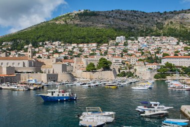 Dubrovnik. Hırvatistan - 20 Kasım 2025: Hırvatistan 'ın Dubrovnik Eski Limanı manzarası. Adriyatik Denizi 'nde ortaçağ şehir duvarları ve Srd Dağı' na karşı güneşli bir günde tekneler.