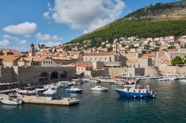 Dubrovnik. Hırvatistan - 20 Kasım 2025: Hırvatistan 'ın Eski Dubrovnik Limanı' nın panoramik manzarası. Adriyatik Denizi 'nde ortaçağ şehir duvarları ve Srd Dağı' na karşı güneşli bir günde tekneler.