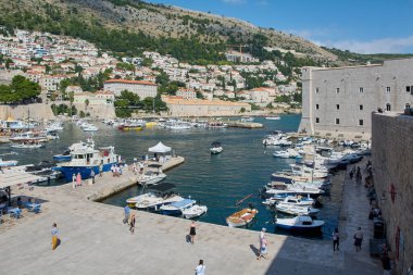 Dubrovnik. Hırvatistan - 20 Kasım 2025: Tarihi limanda tekneli ünlü Dubrovnik şehri. Güzel bir yaz gününde Dalmaçya kıyılarında popüler bir UNESCO turizm beldesi.