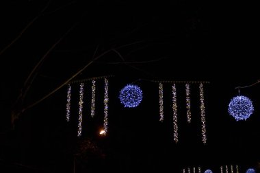 Barcelona 'da karanlık bir gece gökyüzüne karşı stilize karakterler ve geometrik süsler içeren yaratıcı bir LED tatil ışığı koleksiyonu.