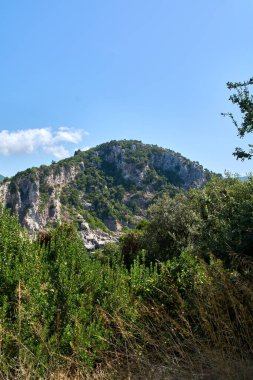 Tarihi Angelokastro kalesinin nefes kesici manzarası Korfu 'daki yemyeşil Akdeniz bitkileriyle çevrili engebeli bir kireçtaşı uçurumuna tünemişti..