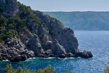 Çarpıcı yüksek açılı dramatik kayalık manzarası kristal berrak İyon Denizi ile Korfu, Paleokastritsa kıyıları boyunca buluşuyor..