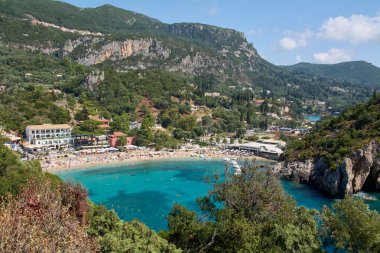 Ünlü Paleokastritsa Körfezi 'nin çarpıcı yüksek açılı manzarası kristal berraklığında turkuaz sular, kumlu bir sahil ve yemyeşil dağlarla dolu..