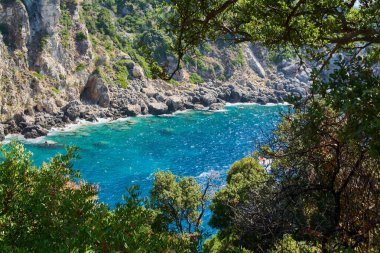Paleokastritsa, Corfu 'nun nefes kesici güzelliğini keşfedin. Kristal berraklığında turkuaz sular, engebeli kireçtaşı kayalıkları ve yemyeşil yeşillikler..