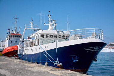 Korfu. Yunanistan - 29 Ocak 2026: Açık mavi gökyüzü altında demirlemiş ticari ve hizmet gemileri, deniz taşımacılığı, lojistik operasyonları, kıyı altyapısını vurguluyor