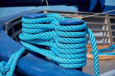 Güvertenin etrafına sarılı mavi demirleme halatları bir gemiye sarılı, güçlü dokuları ve canlı renkleri ile deniz düzeni, güvenlik ve denizcilik hazırlık vurgulanıyor nakliye ve deniz kavramları için ideal.