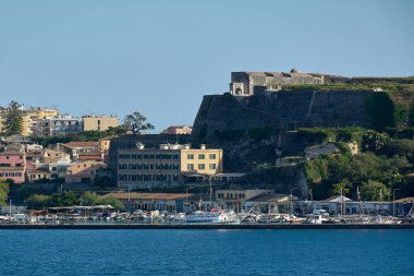 Korfu. Yunanistan - 03 Şubat 2026: Marina ve liman binaları, sakin mavi deniz ve Akdeniz mirası, turizm ve seyahat cazibesini ön plana çıkaran tekneleriyle birlikte tarihi kıyı kenti
