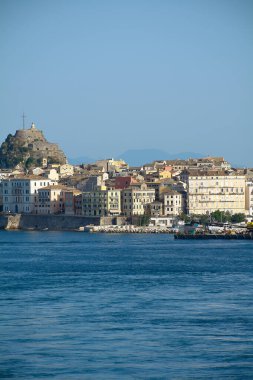 Pastel cepheleri, tarihi kale tepeleri ve sakin İyon Denizi ile Corfu 'nun liman manzarası Akdeniz mirası, kıyı kentsel yaşam ve turizm cazibesi