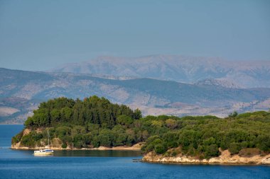 Çapalı yelkenli teknesi, yemyeşil adaları ve katmanlı dağları olan sakin bir sahil koyunda huzurlu bir kaçış, birinci sınıf seyahat havası ve doğal denge turizm, refah ve yaşam tarzı markalaşması için ideal.