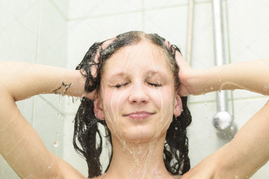 Portrait of woman smiling under hot shower streams