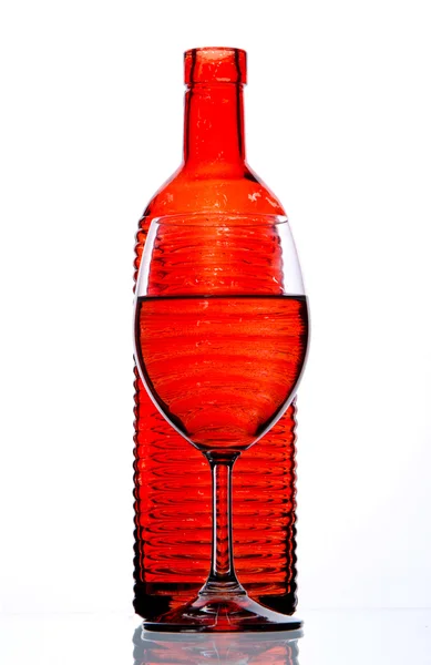 Red bottle and filled glass — Stock Photo, Image