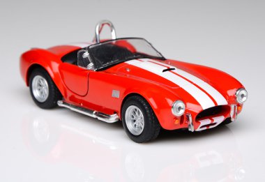 Maket oyuncak plastik kırmızı araba beyaz bir arka plan üzerinde.