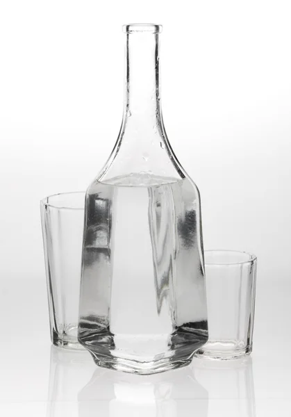 Two glasses and a decanter on grey white background — Stock Photo, Image