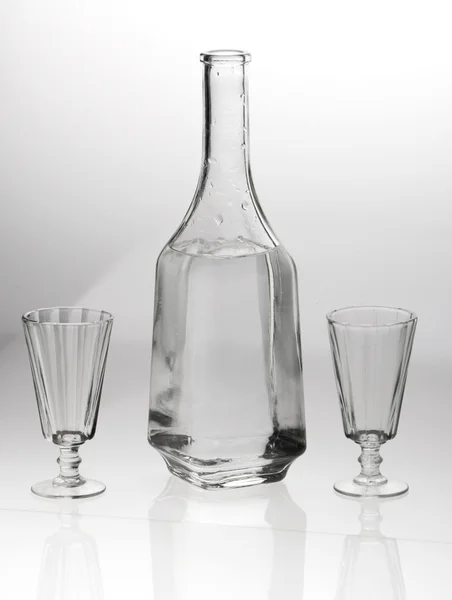 Due bicchieri e un decanter su sfondo grigio bianco — Foto Stock