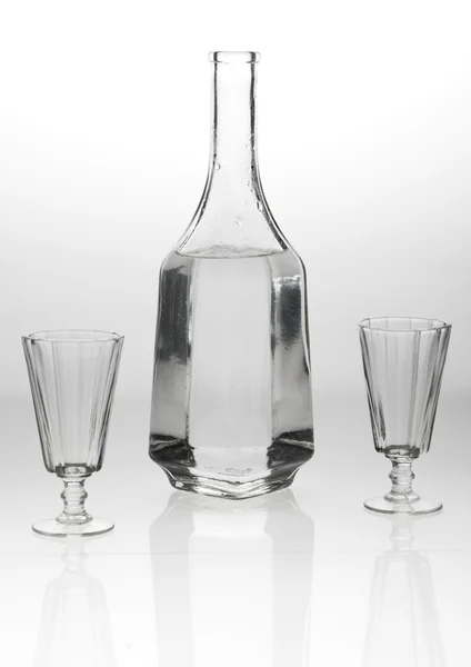 Due bicchieri e un decanter su sfondo grigio bianco — Foto Stock