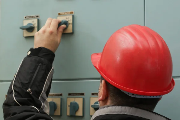 Técnico con casco rojo apague el interruptor de encendido — Foto de Stock