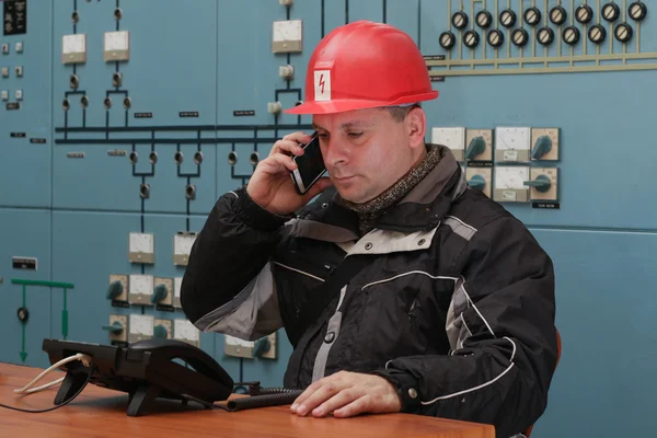 Técnico hacer llamadas de teléfono móvil en el centro de control de la planta de energía — Foto de Stock