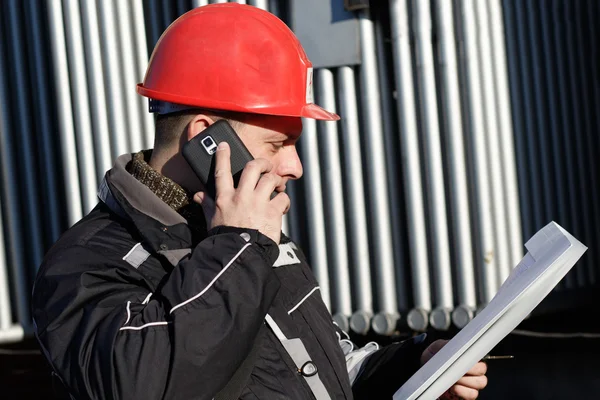 Técnico en casco rojo hacer llamada en la planta de energía — Foto de Stock