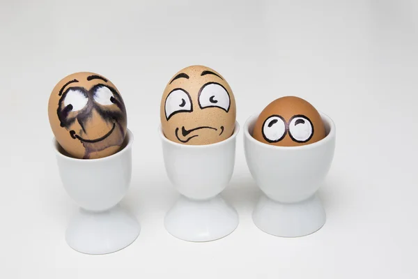 Drie eieren met bang gezicht in eggcup — Stockfoto