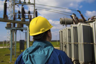 Mühendis yüksek gerilim transformerstation kontrol ediyor