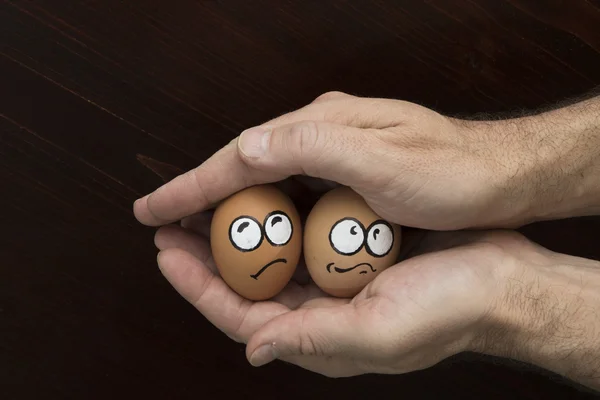 Cara de huevo asustada en la mano del hombre — Foto de Stock