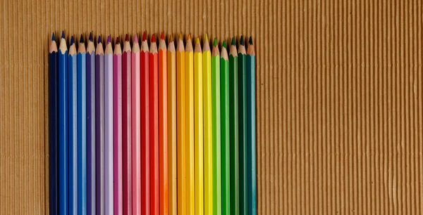 Lápices multicolores sobre papel arrugado —  Fotos de Stock