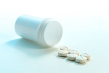 Beyaz arka planda beyaz tablet ve plastik şişe grubu