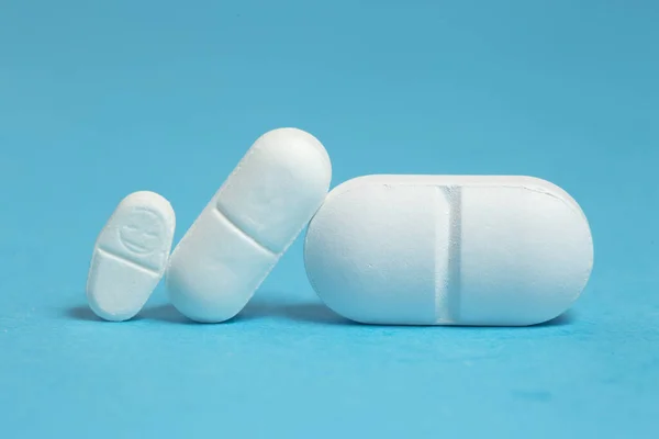 Tres Comprimidos Blancos Diferentes Tamaños Azul Dosificación — Foto de Stock