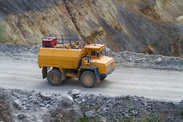 Caminhão amarelo com canhão de água na mineração de superfície coper — Fotografia de Stock