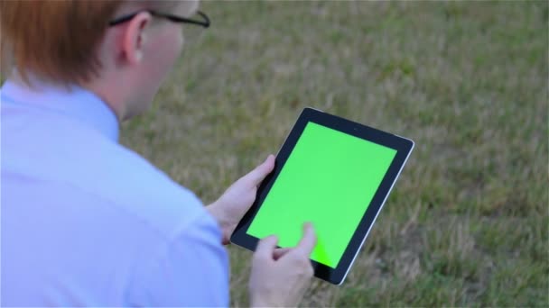 Ο άνθρωπος χρησιμοποιώντας ψηφιακή δισκίο υπολογιστή οθόνη αφής με μια πράσινη οθόνη — Αρχείο Βίντεο