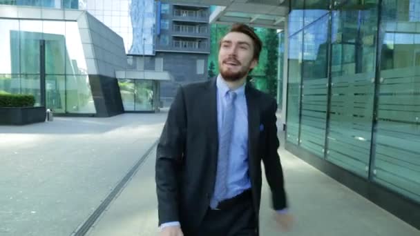 Gelukkig zakenman is dansen op straat in de buurt van het office-center dragen pak viering van zijn prestaties (steadicam schot) — Stockvideo