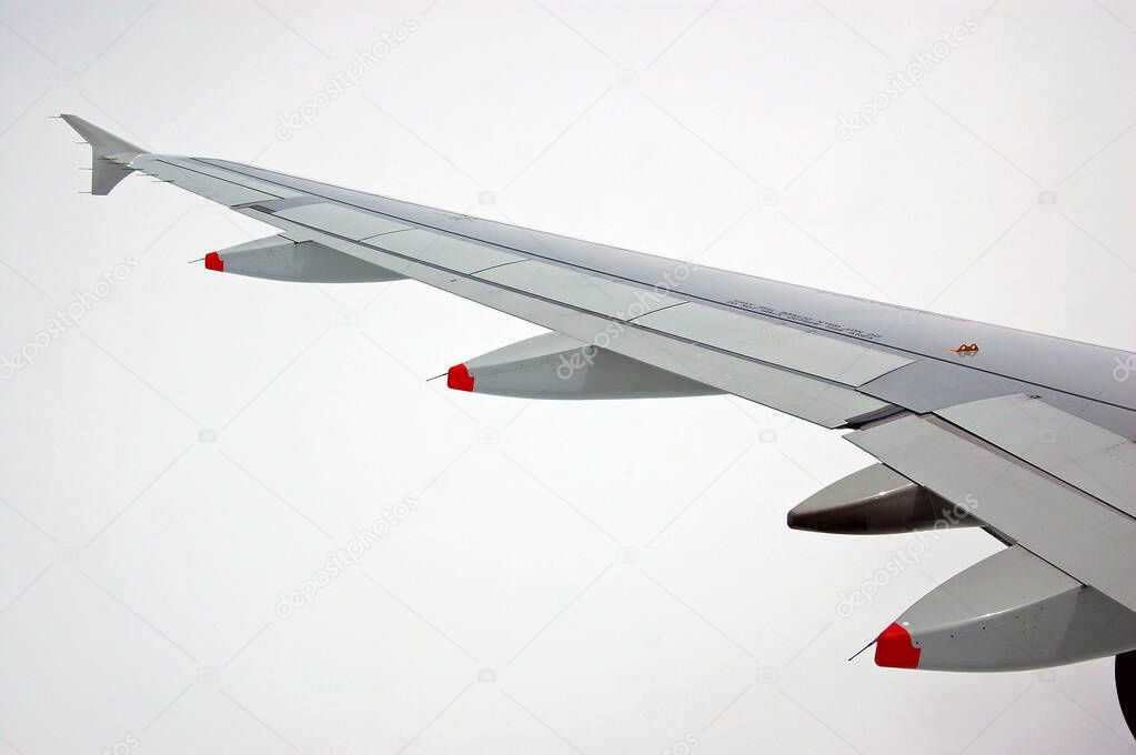 View from the cabin of an Airborne wing of an Airbus A320 plane. White cloud background.