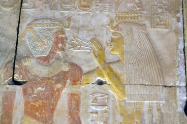 Abydos 'taki Seti I tapınağının iç duvarına Heiroglyphic oyma. Antik Mısır tanrıçası kutsal anhk 'ı Firavun Seti I' nin yüzüne tutuyor..  
