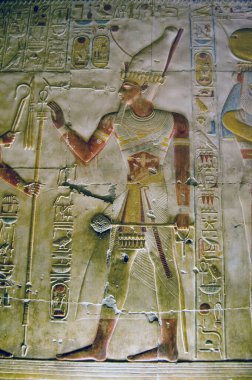 Eski Mısır hiyerogliflerinin boyanmış hali, Firavuna ait bir sopa ya da asa taşıdığını gösteriyor. Mısır 'ın Abydos kentindeki Osiris tapınağının iç duvarı.