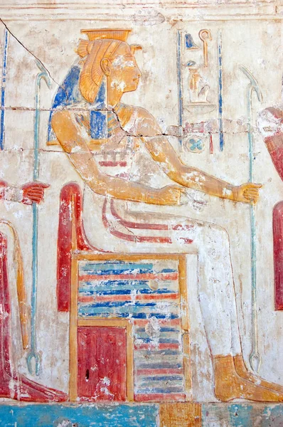 An Ancient Egyptian carved hieroglyphic painting of the goddess Mut. One of the symbolic mothers of the king, she is shown with a vulture headdress. Wall of the Temple of Ramses II, Abydos, Egypt.