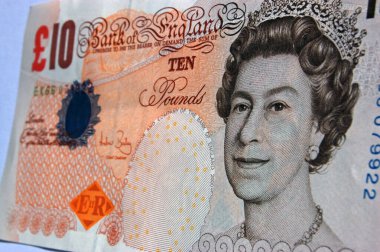 Kraliçe 2. Elizabeth 'in görüntüsünün yer aldığı eski moda bir kağıt parçasına basılmış artık kullanılmayan 10 sterlinlik bir banknotun resmi..